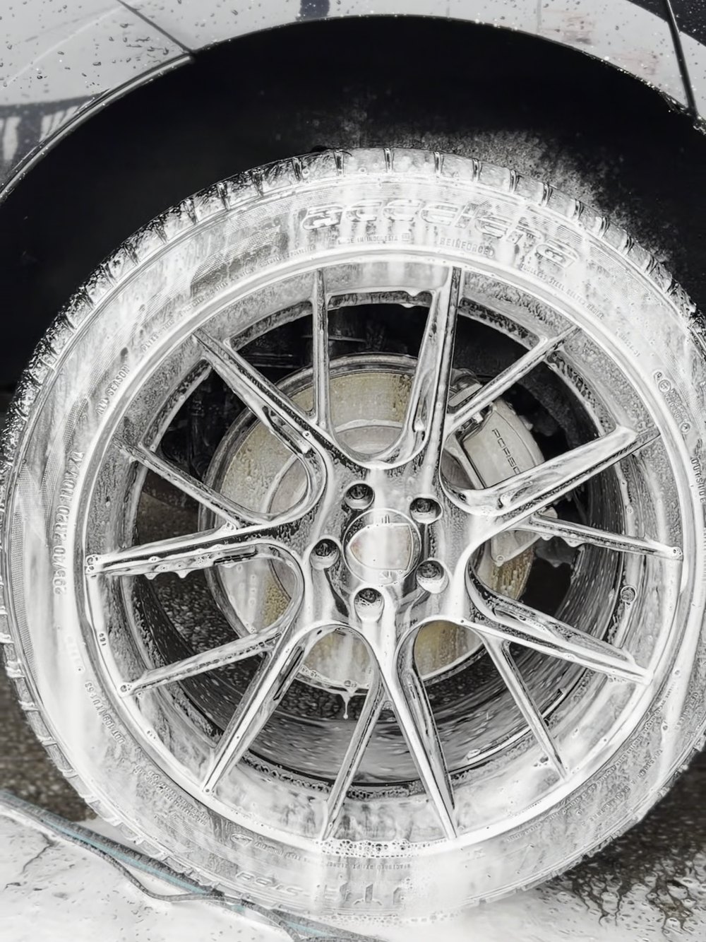 Alloy wheel covered in foam during a dedicated wheel clean